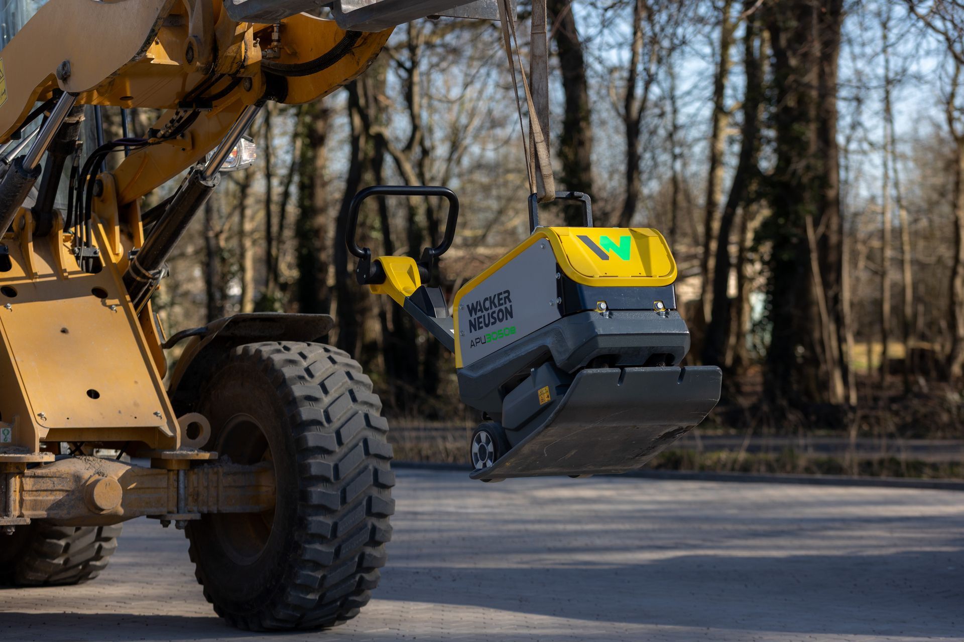 Ein gelb-schwarzes Baufahrzeug steht am Straßenrand