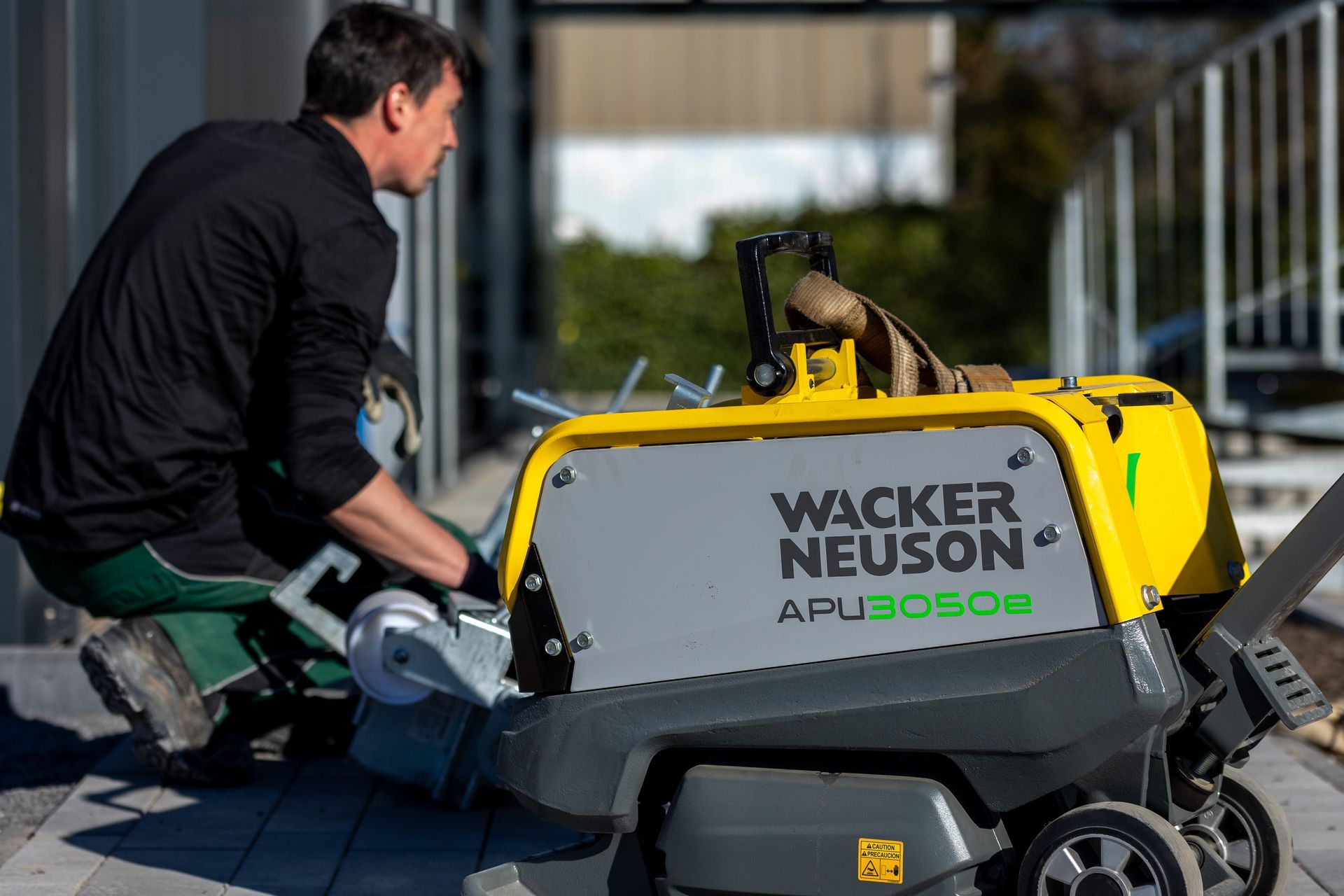 Ein Mann arbeitet auf dem Bürgersteig an einer Maschine