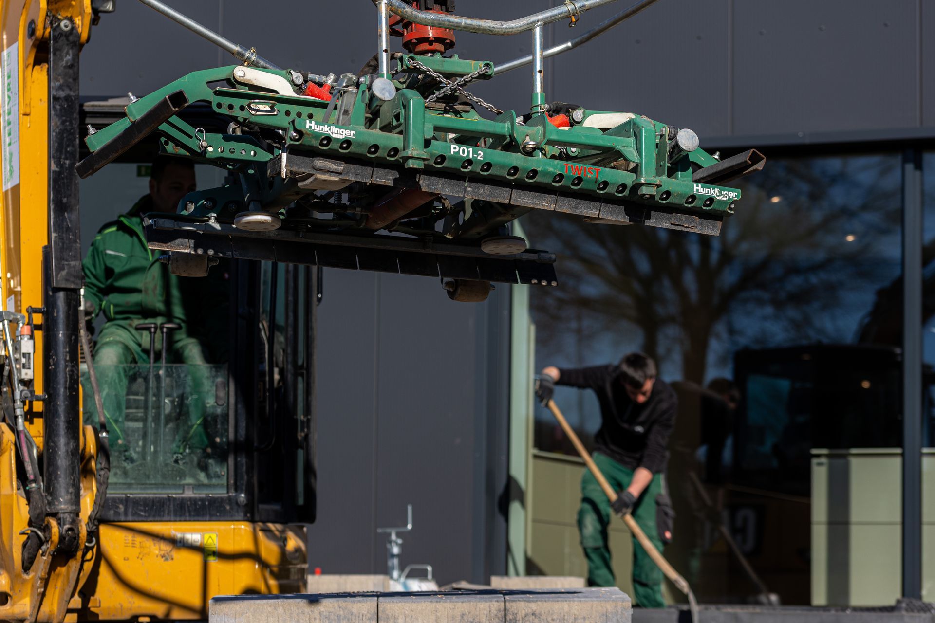 Ein Mann steht mit einer Schaufel neben einem Kran