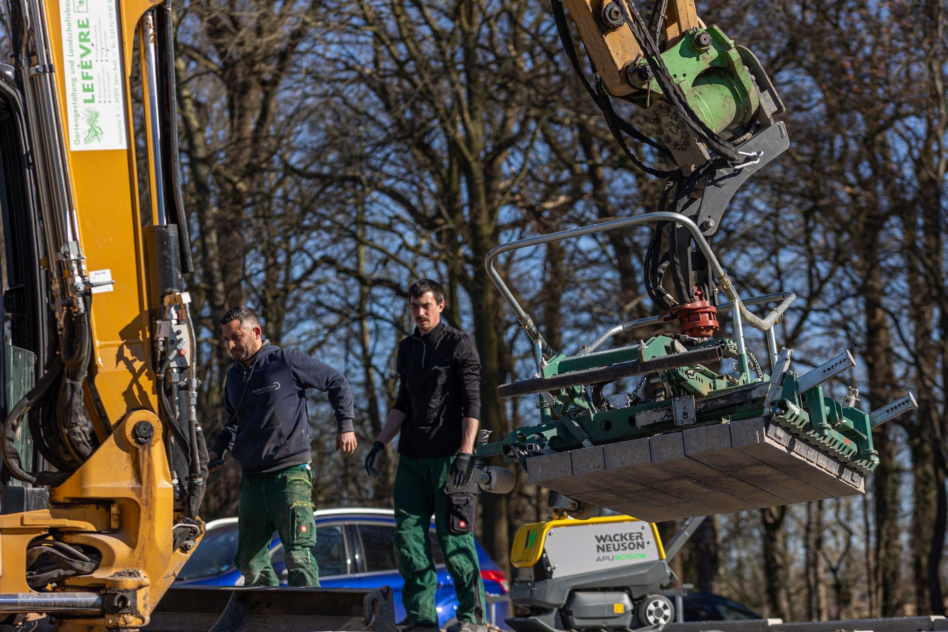 Zwei Männer stehen neben einem großen Bagger