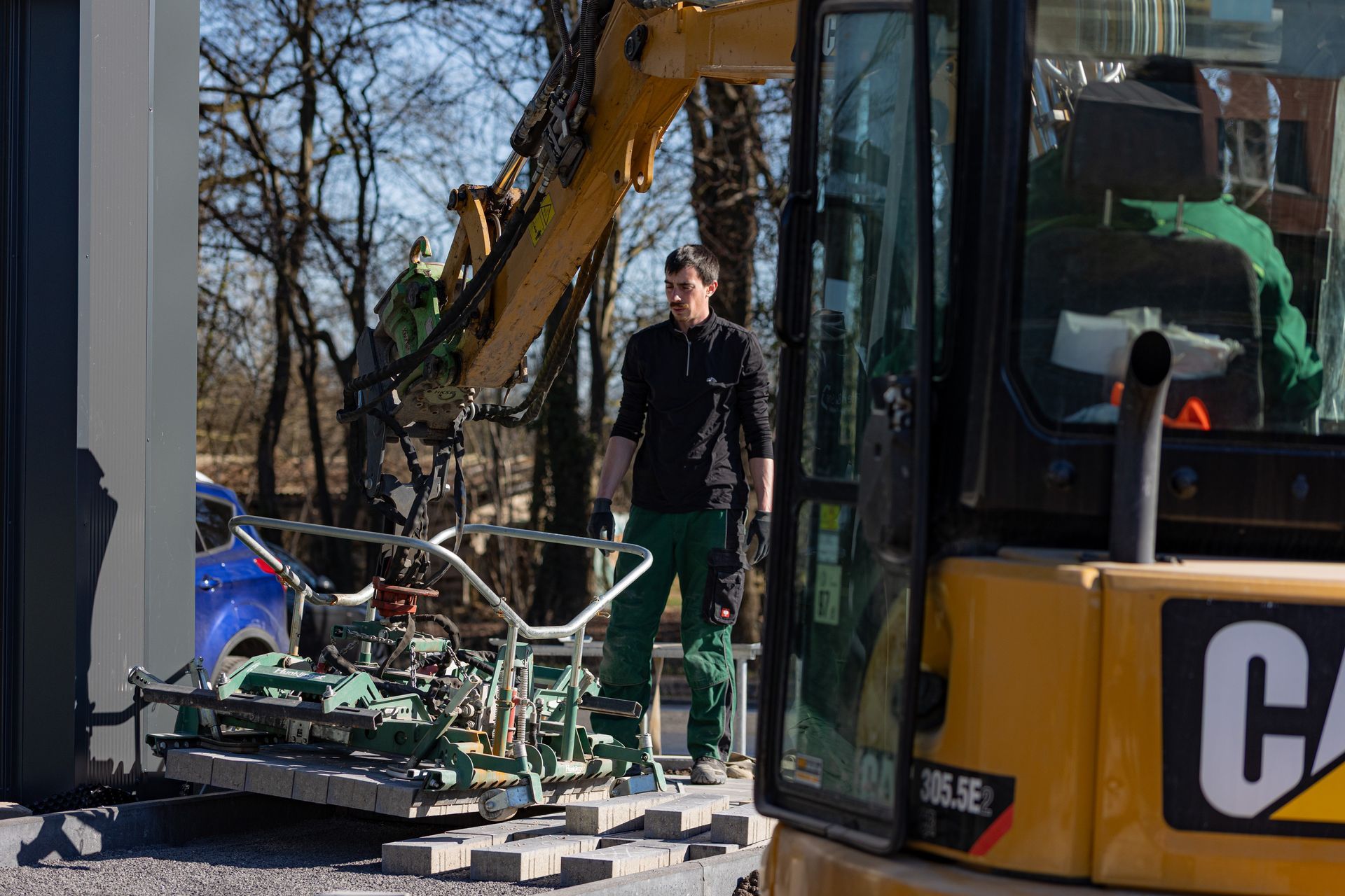 Ein Mann steht auf einer Baustelle neben einem Cat-Bagger
