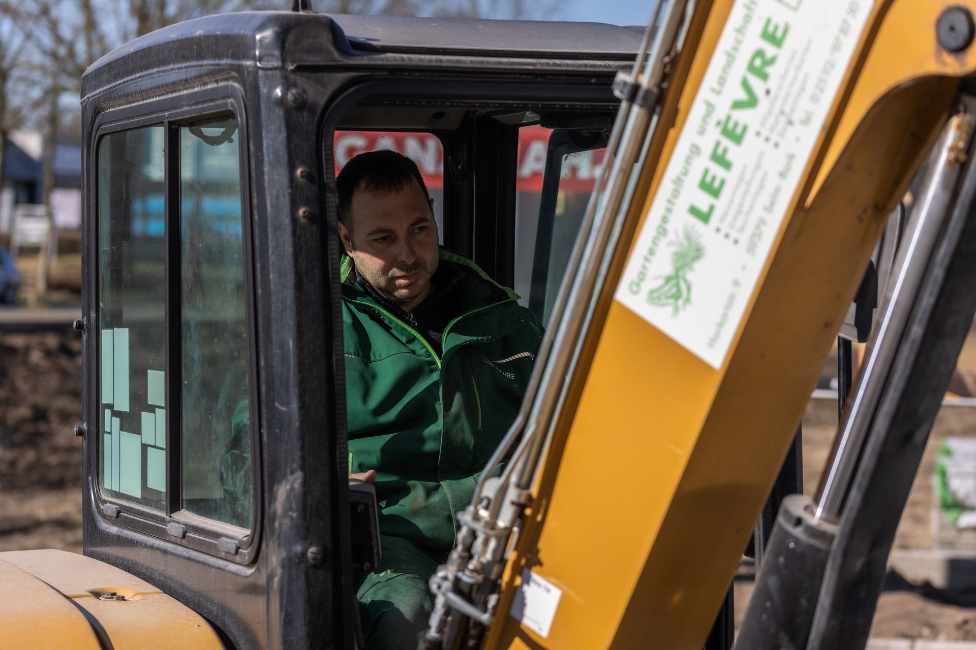 Ein Mann sitzt auf dem Fahrersitz eines Lefevre Baggers