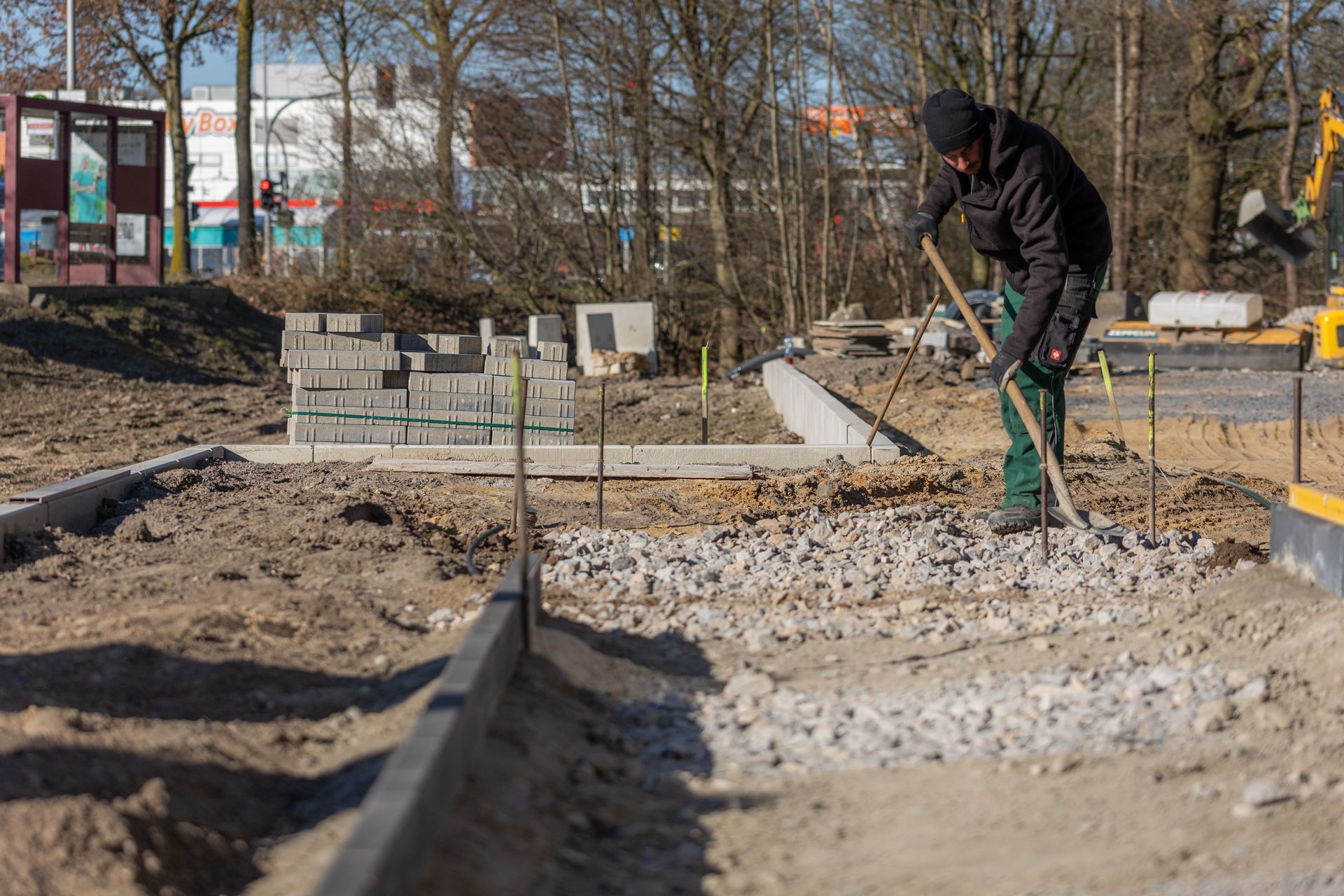 Ein Mann arbeitet mit einer Schaufel auf einer Baustelle