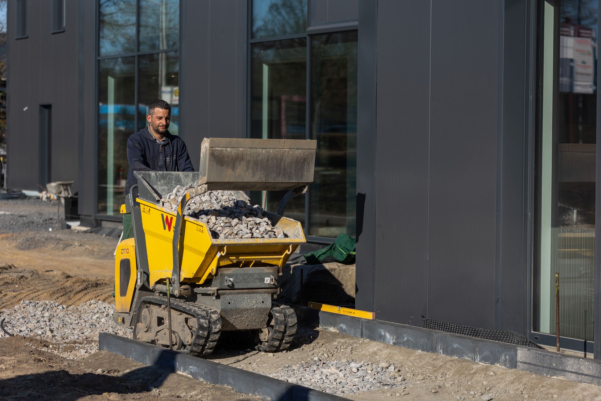 Ein Mann fährt einen Muldenkipper auf einer Baustelle