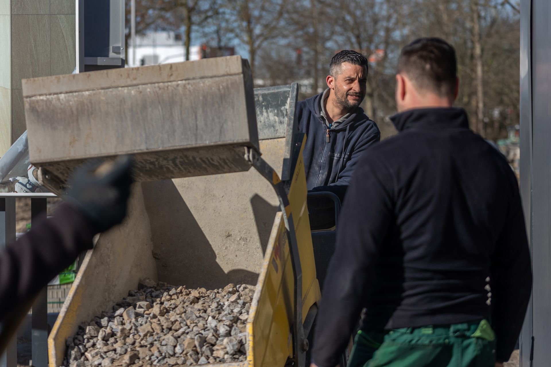 Zwei Männer stehen neben einem mit Steinen beladenen Lastwagen