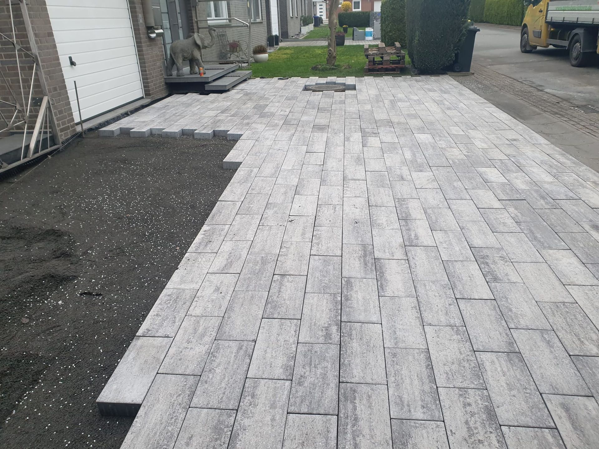 Vor einem Haus wird ein gemauerter Gehweg gebaut