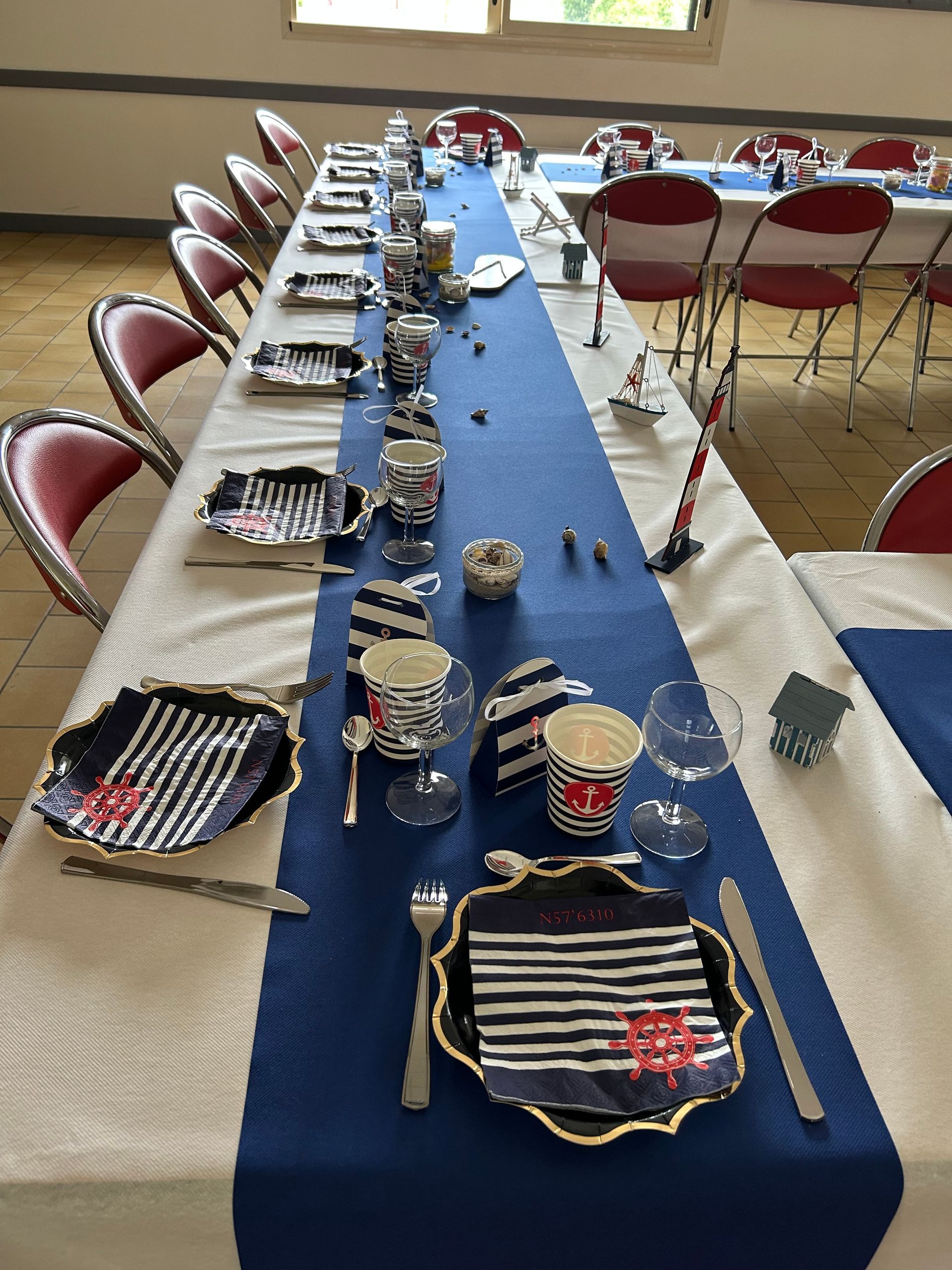 Une table vue de haut avec un chemin de table bleu, des assiettes et des couverts dessus