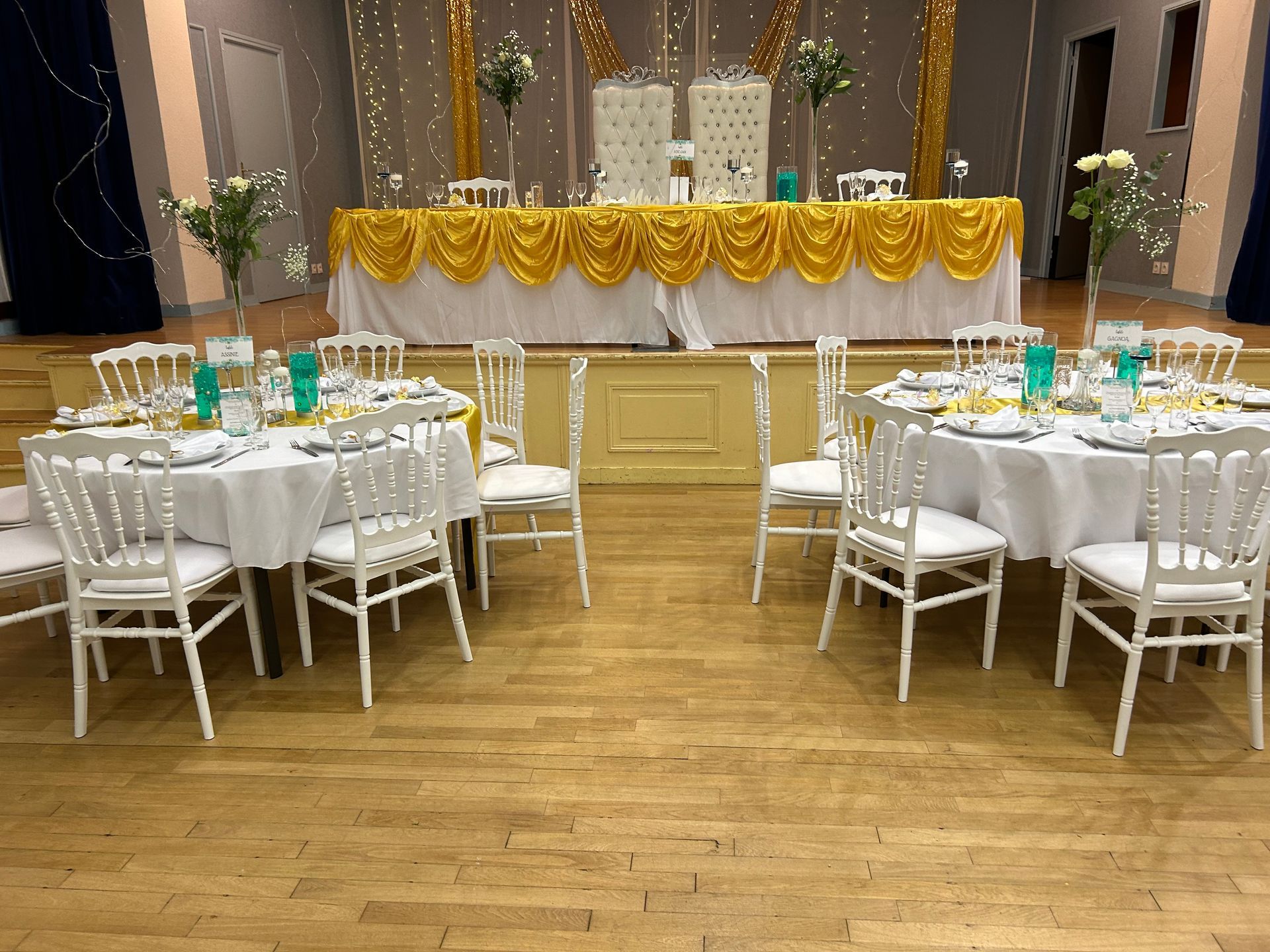 Salle de réception avec tables décorées dans des tons dorés et blancs