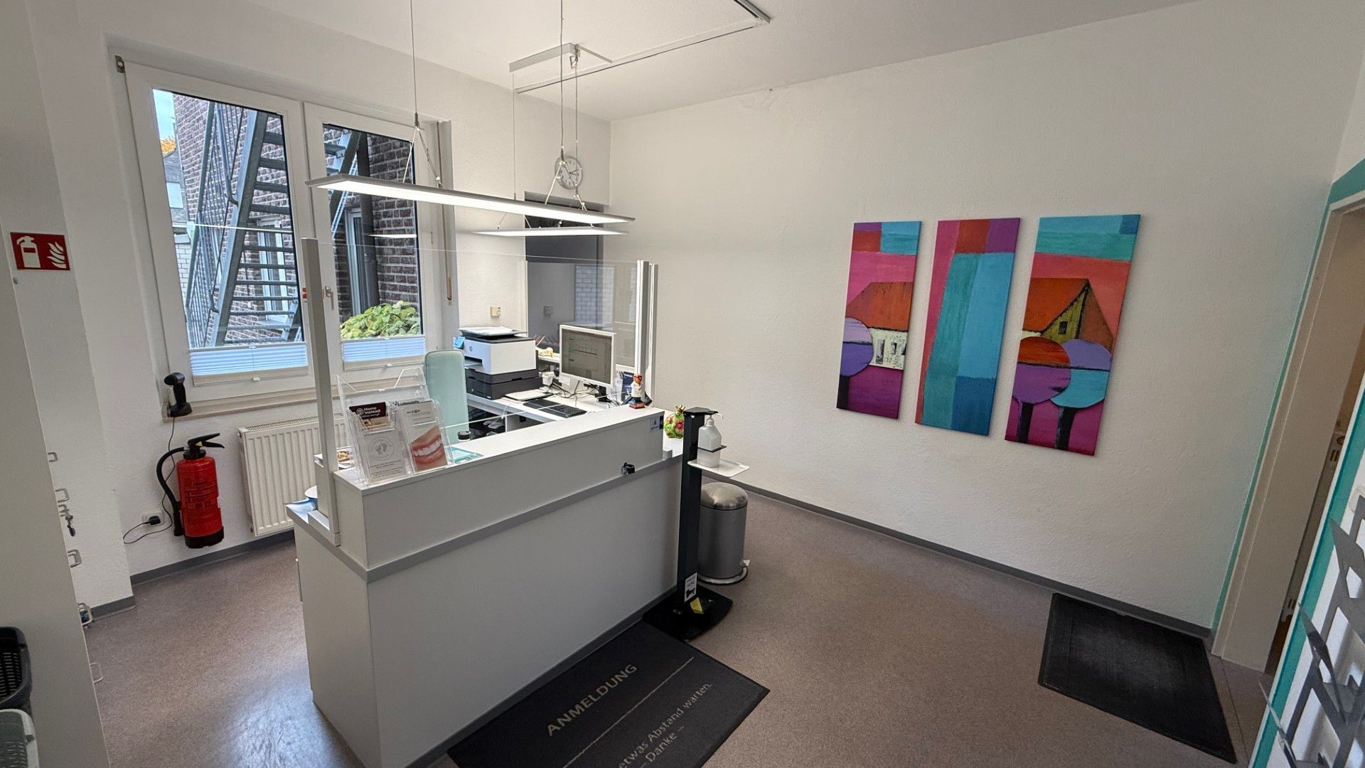 Heller Empfangsbereich einer Praxis mit Anmeldungstresen.