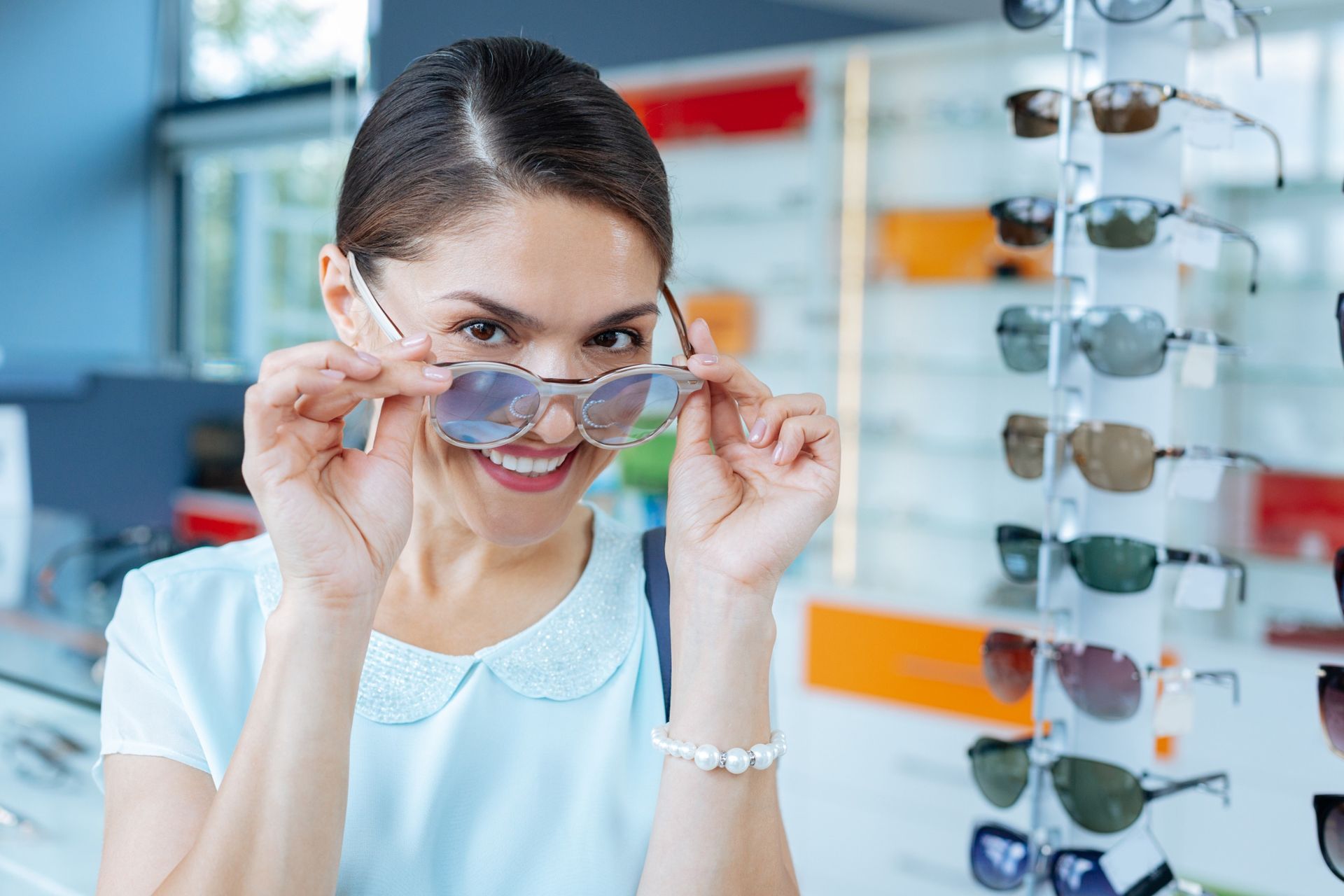 Una mujer se prueba gafas de sol en una óptica.