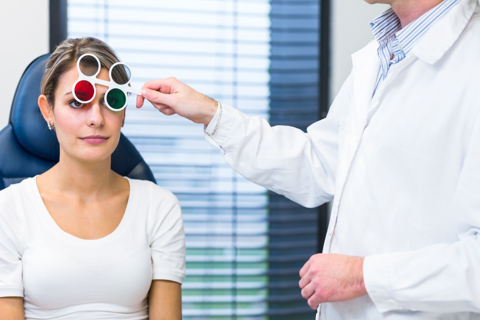 Una mujer se pone una lente de contacto en su ojo verde.