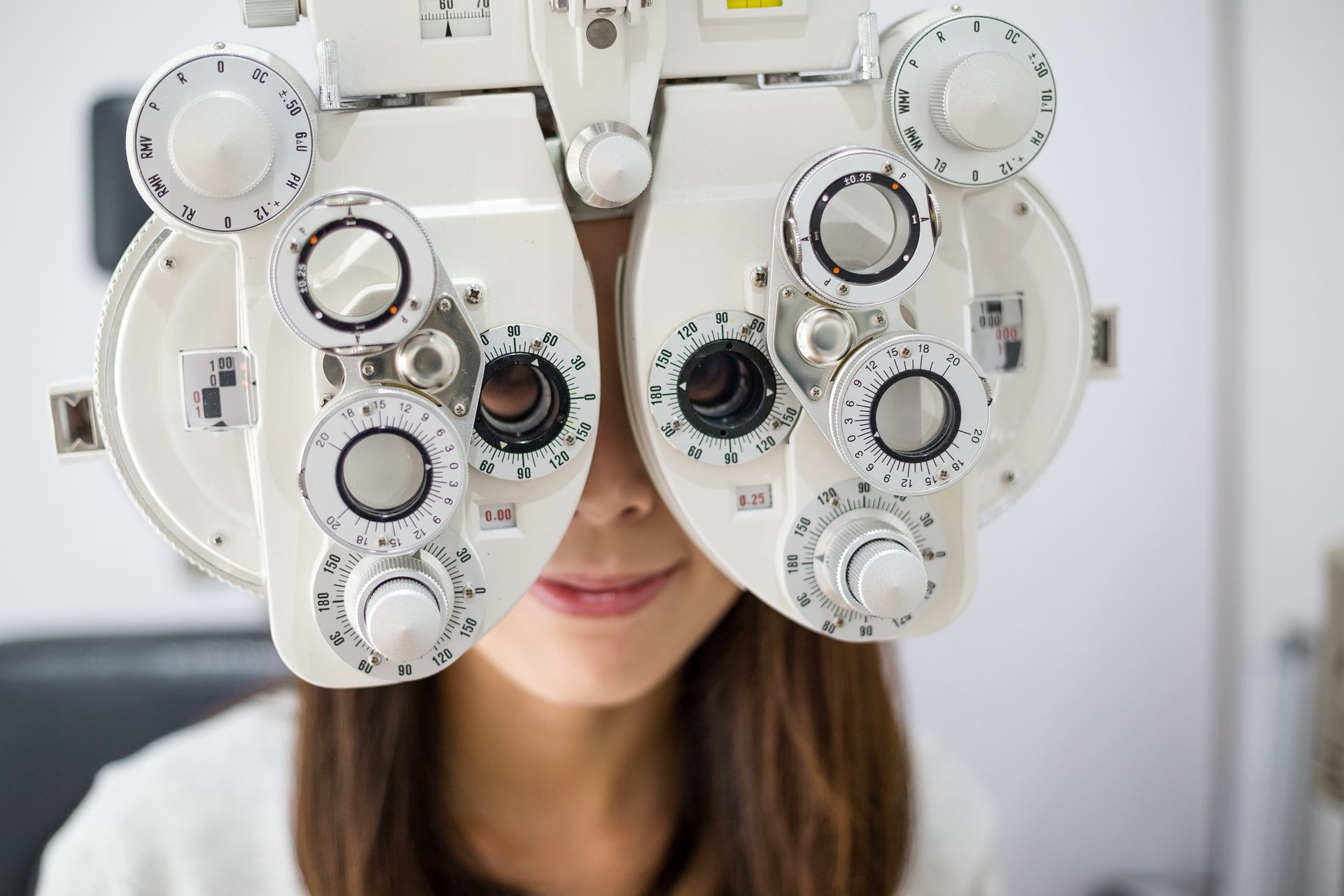 Una mujer se pone una lente de contacto en su ojo verde.