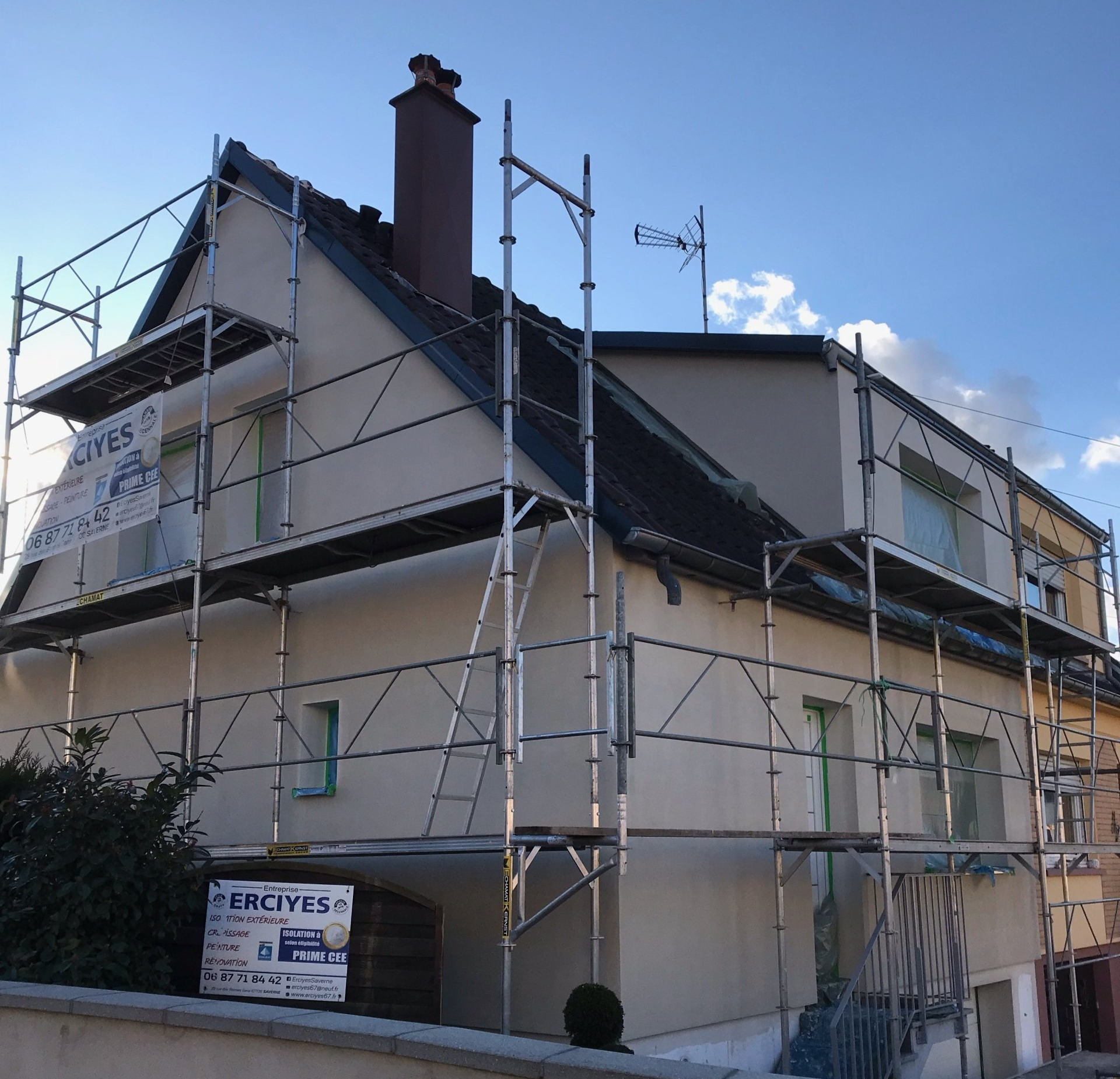 Extérieur de maison avec échafaudage pour travaux de rénovation.