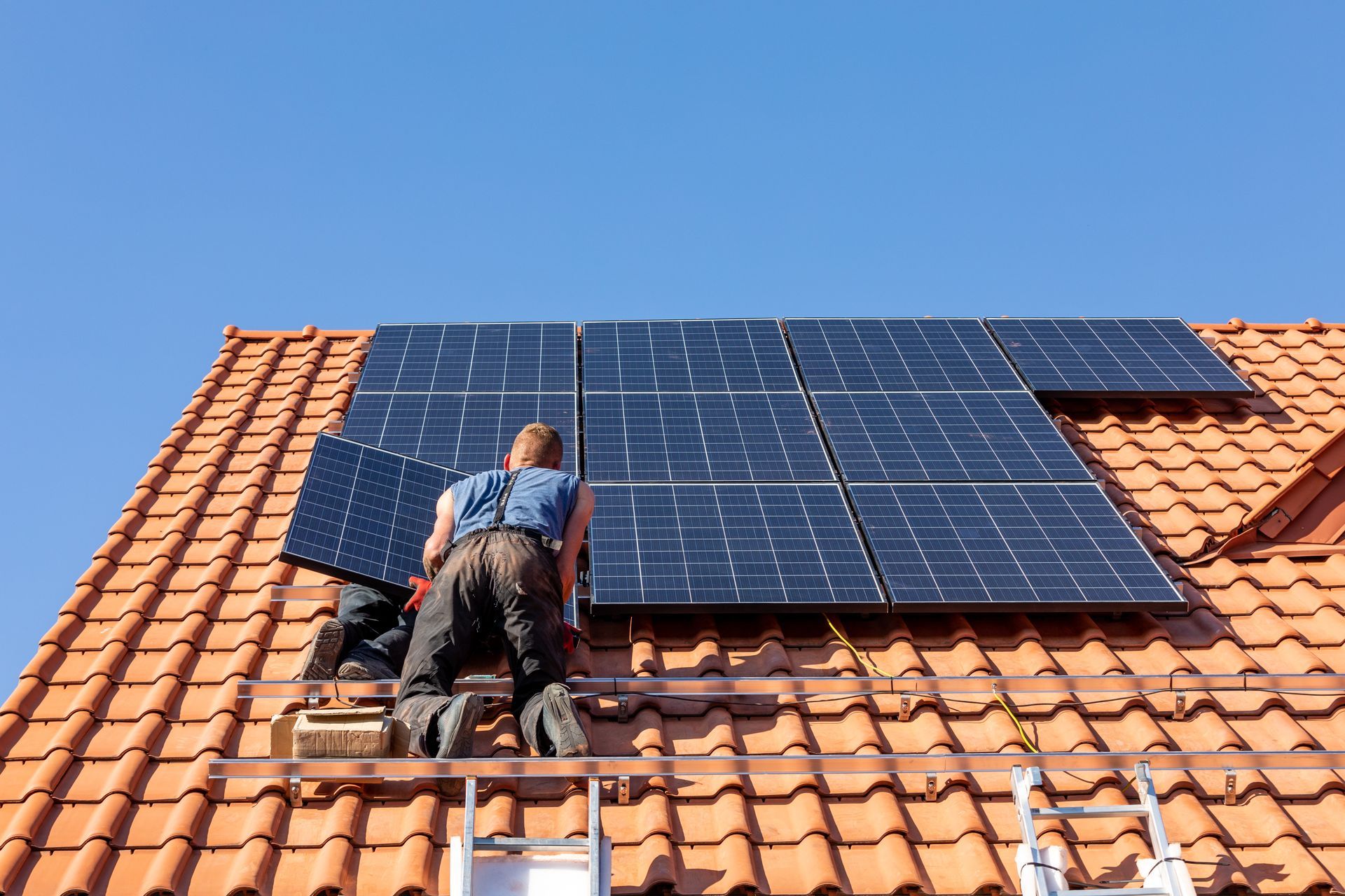 Un artisan qui pose des panneaux solaires