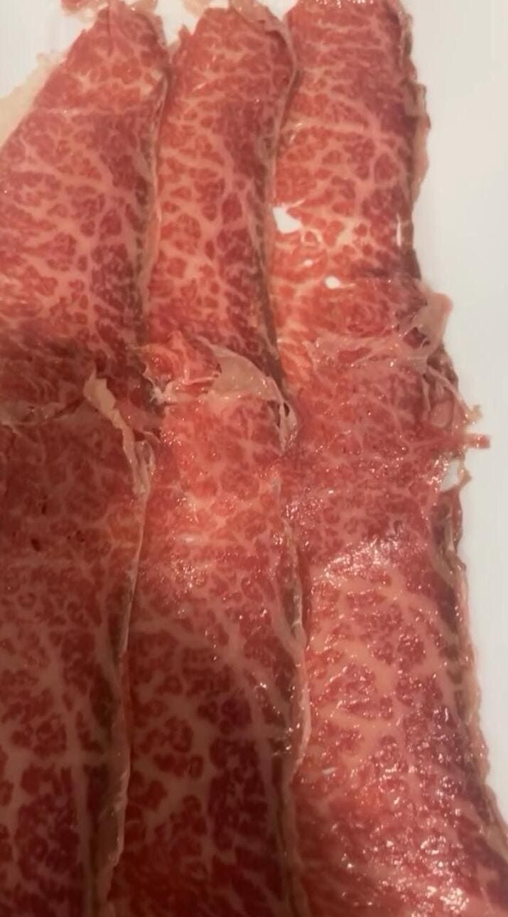 Un primer plano de un trozo de carne en un plato blanco.
