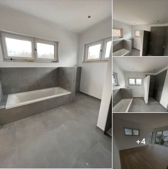 Modernes Badezimmer mit grauen Boden- und Wandfliesen, einer eingebauten weißen Badewanne und einem separaten begehbaren Duschbereich.