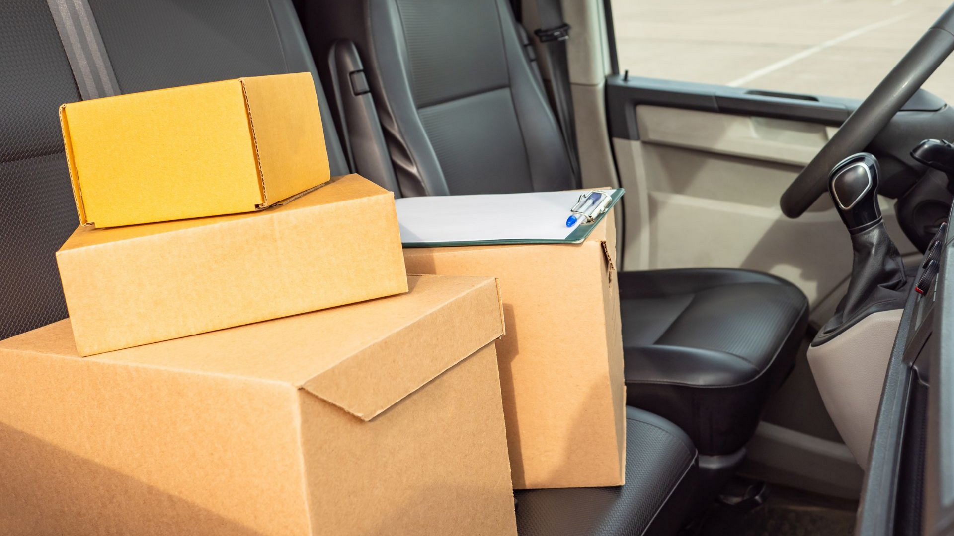 Des cartons sur le siège avant d'une camionnette, prêts à être livrés.