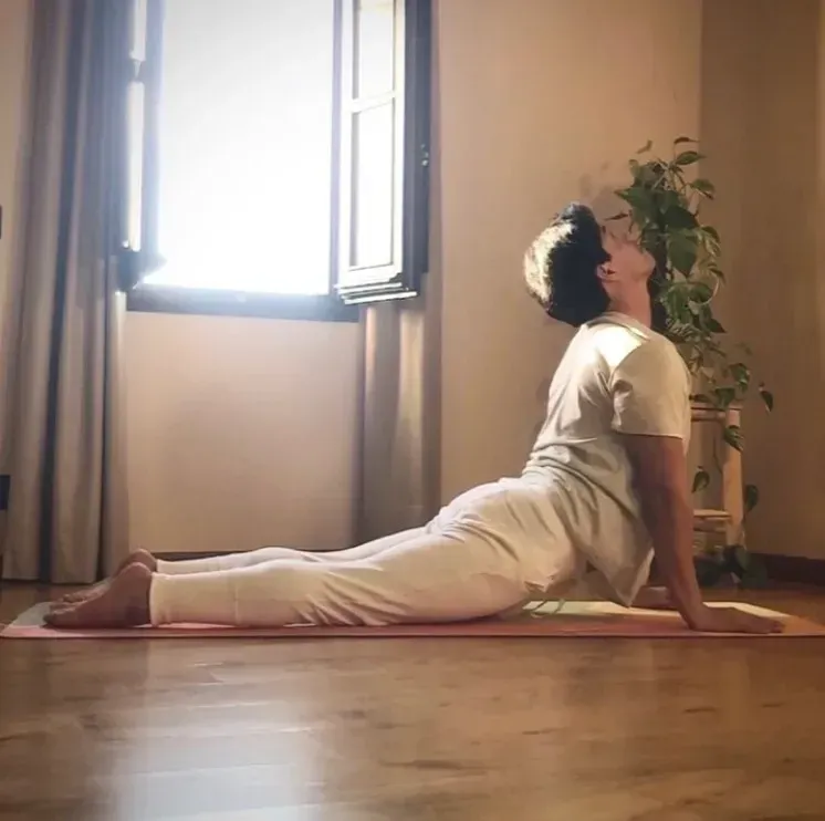 Una mujer está tumbada en una esterilla de yoga delante de una ventana.