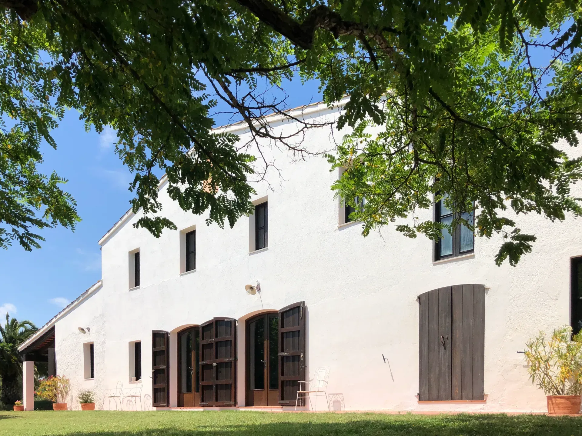 Una casa blanca con contraventanas de madera en las ventanas