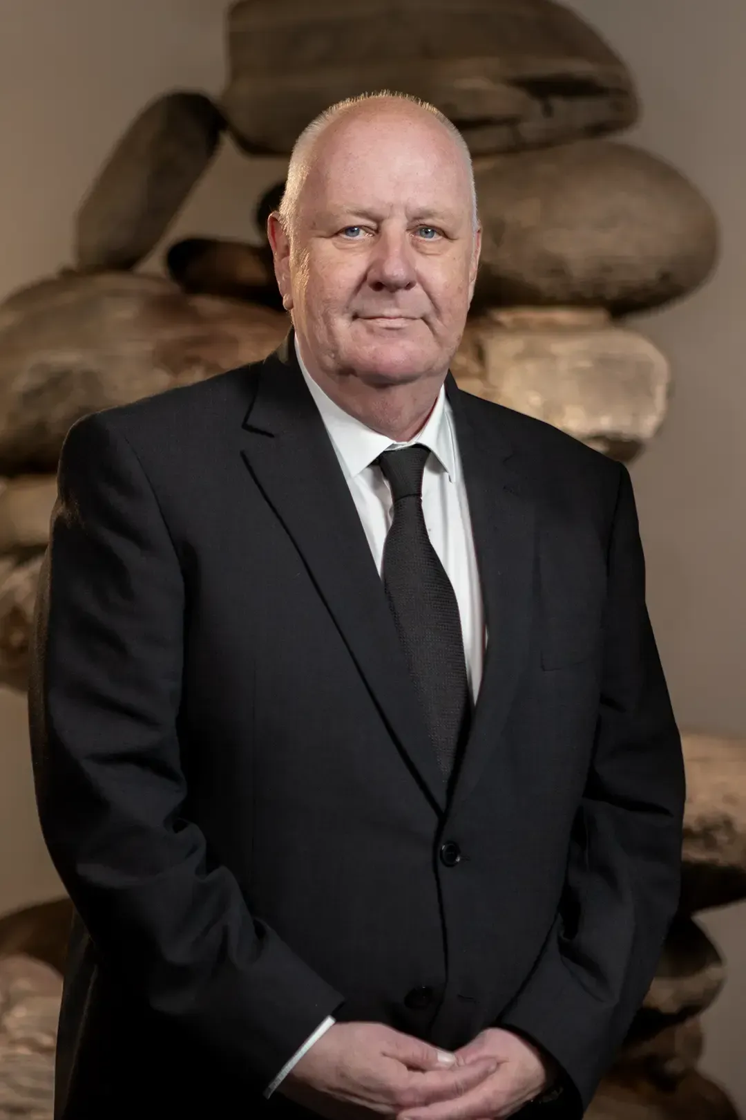 Eine junge Frau mit einem schwarzen Rollkragenpullover und Ohrringen blickt in die Kamera.