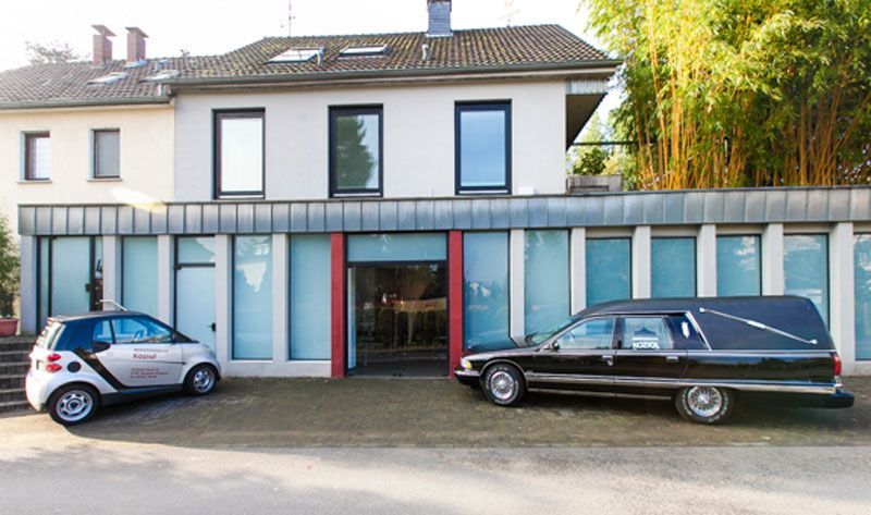 Ein Smart ist vor einem Gebäude geparkt