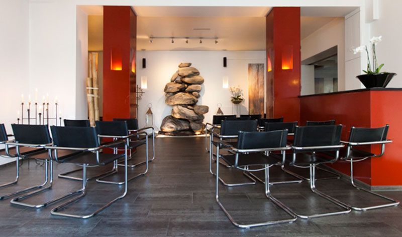 Ein Raum mit schwarzen Stühlen und roten Säulen