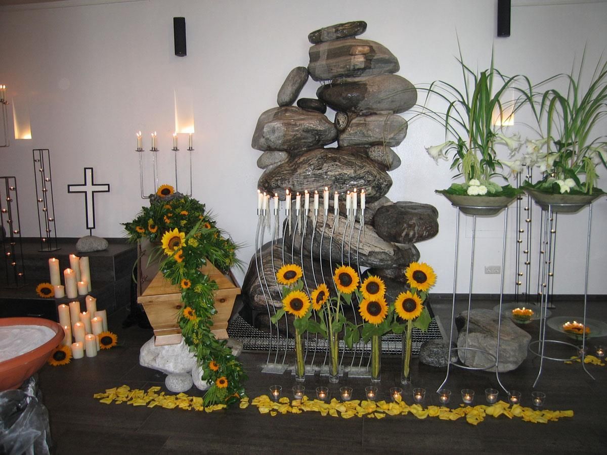 Ein Wasserfall mit Kerzen und Sonnenblumen davor