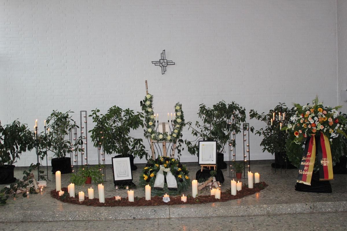 Eine Kirche mit Kerzen und Blumen und einem Kreuz an der Wand
