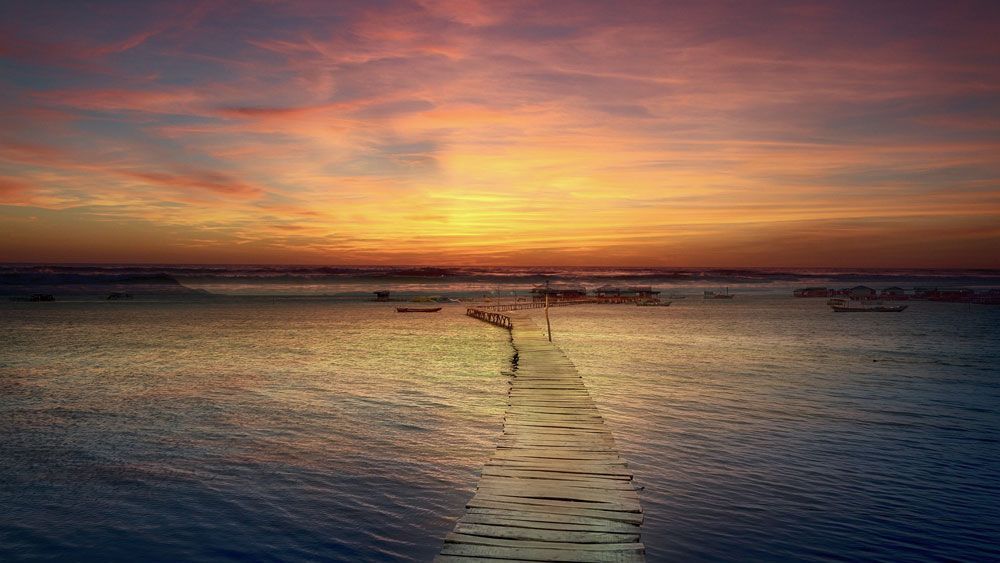 Ein Dock inmitten eines Gewässers bei Sonnenuntergang.