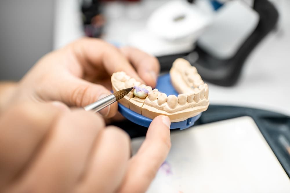Ein Zahnarzt arbeitet an einem Modell der Zähne eines Menschen | Zahnärzte am Westkreuz