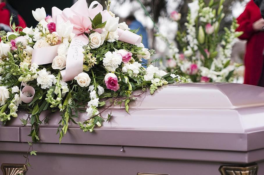 Cercueil violet avec fleurs posées dessus