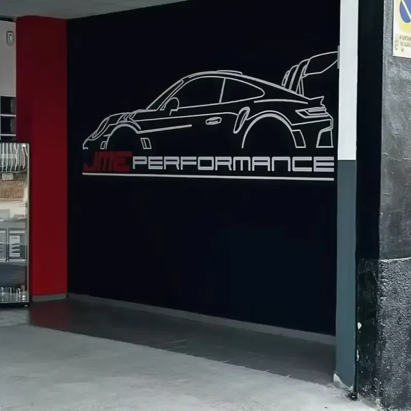 Un mural que muestra la silueta en blanco de un coche deportivo Porsche sobre el logotipo rojo y blanco de 