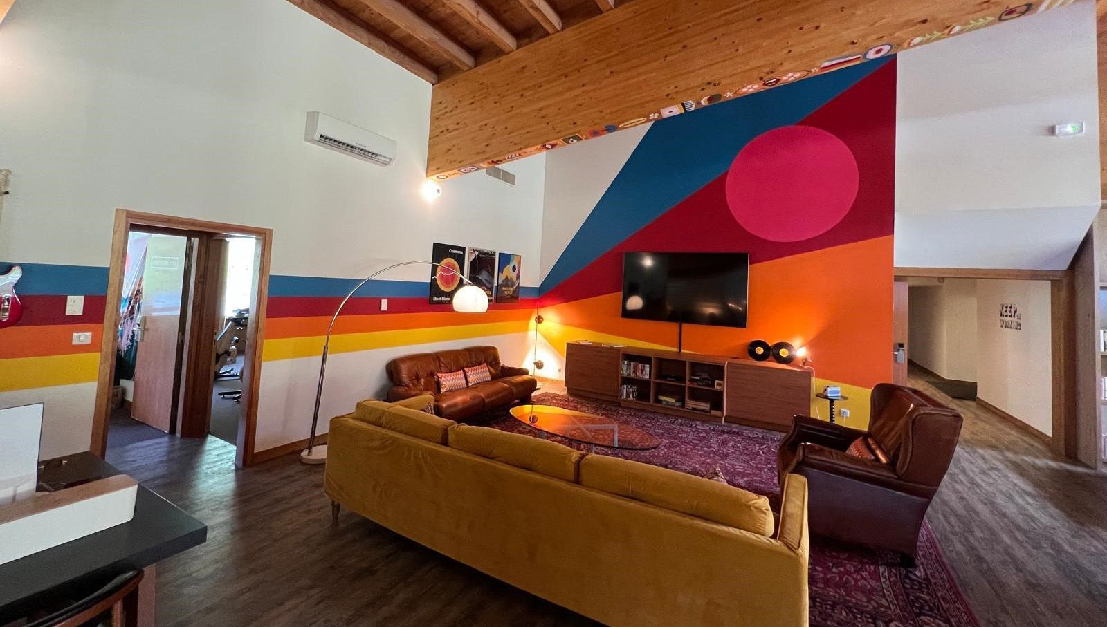 Salon avec un mur marron et un parquet en bois.