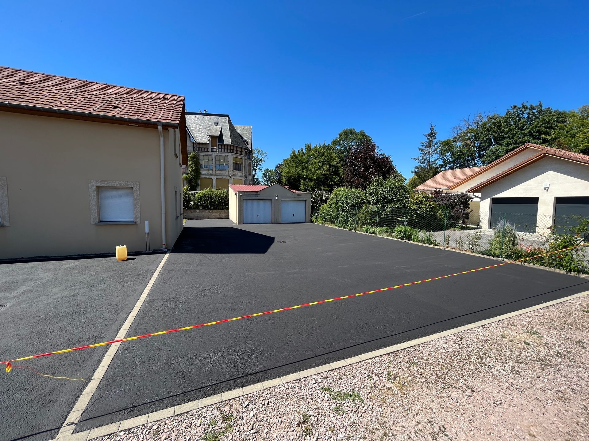 Allée résidentielle calme avec des garages, des maisons beiges et un ciel bleu dégagé