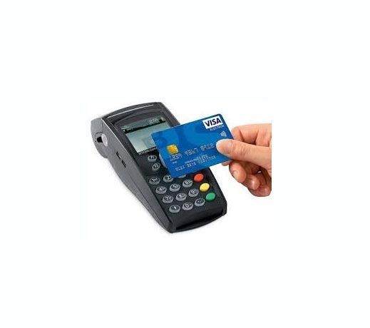 Una persona sostiene una tarjeta de crédito sobre un lector de tarjetas de crédito.