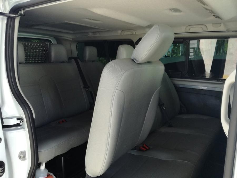 El asiento trasero de una camioneta blanca con asientos grises.