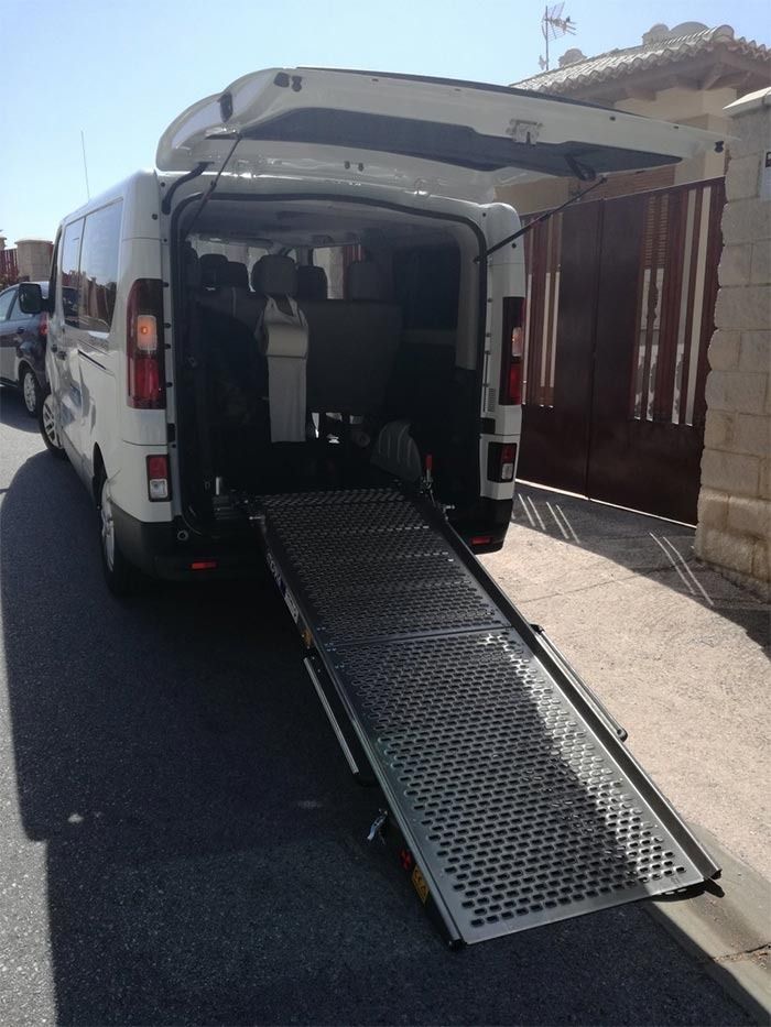 Una camioneta blanca con una rampa en la parte trasera.