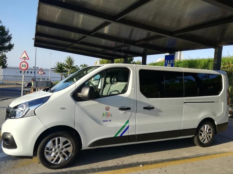 Una camioneta blanca está estacionada bajo un toldo en un estacionamiento.