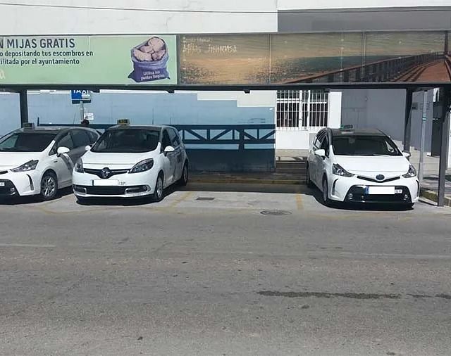 Una fila de autos están estacionados debajo de un cartel que dice gratis