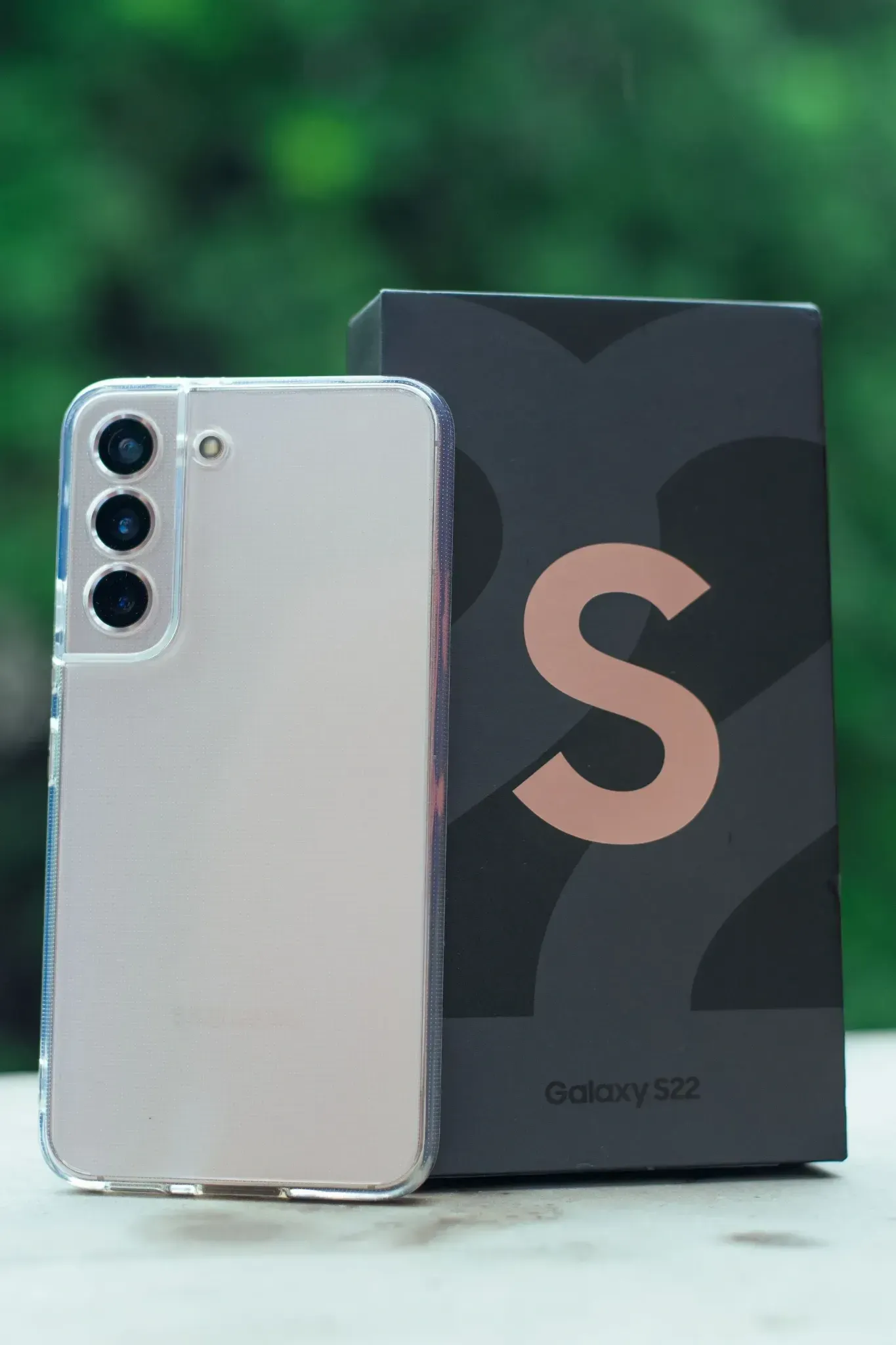 Un teléfono inteligente plateado junto a una caja negra con una