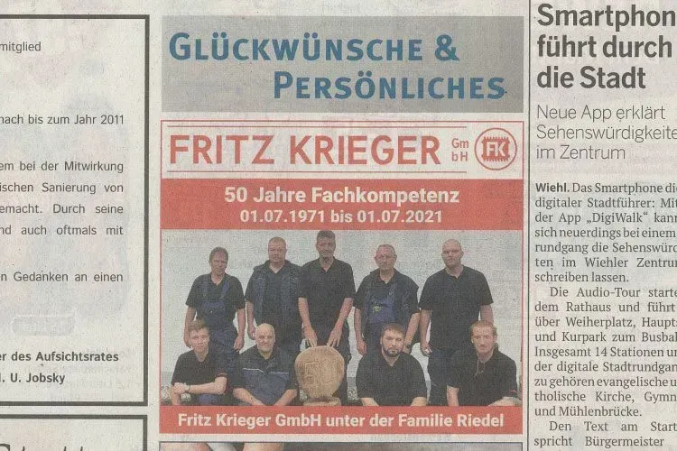 Eine Zeitungsanzeige der Fritz Krieger GmbH zum 50-jährigen Firmenjubiläum mit einem Gruppenfoto der Mitarbeiter.