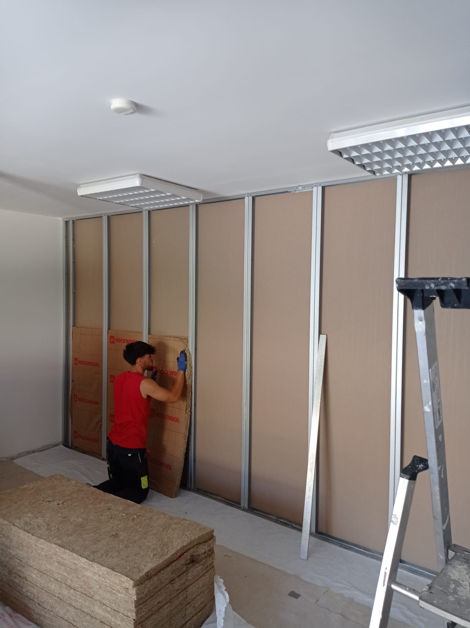 Ouvrier qui pose de l'isolant sur les murs