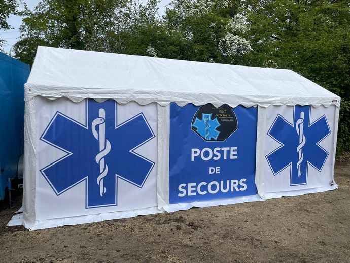 Une tente blanche avec un panneau indiquant poste de secours