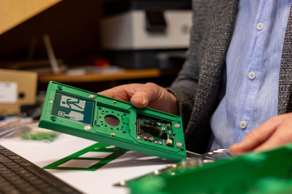 Ein Mann hält eine grüne elektronische Platine in seinen Händen.