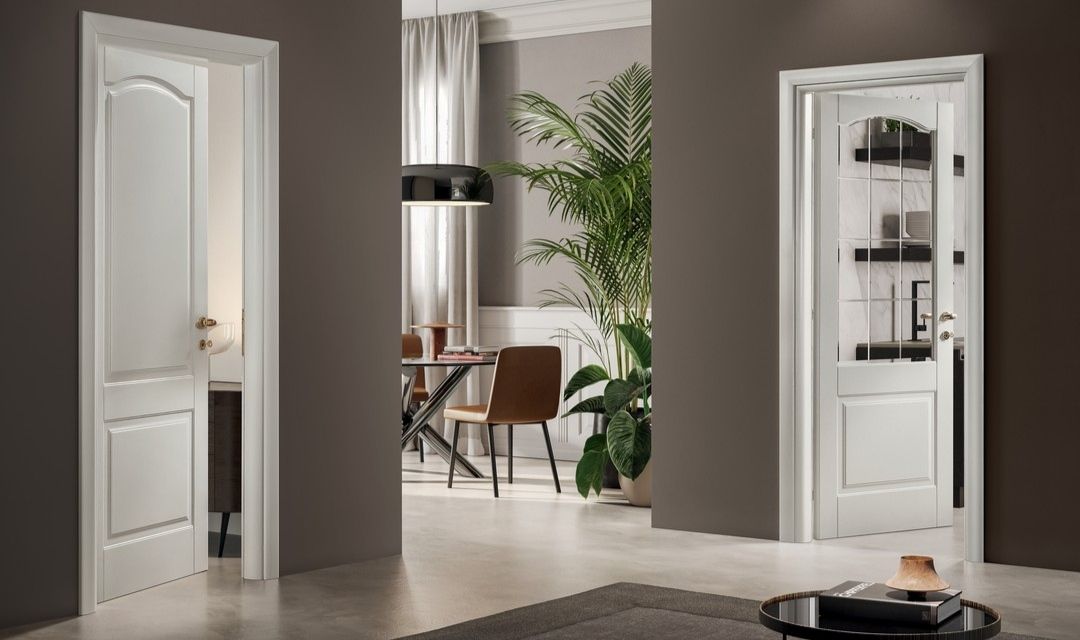 Intérieur avec deux portes à panneaux blancs ; l'une d'elles est vitrée et donne sur un coin repas.