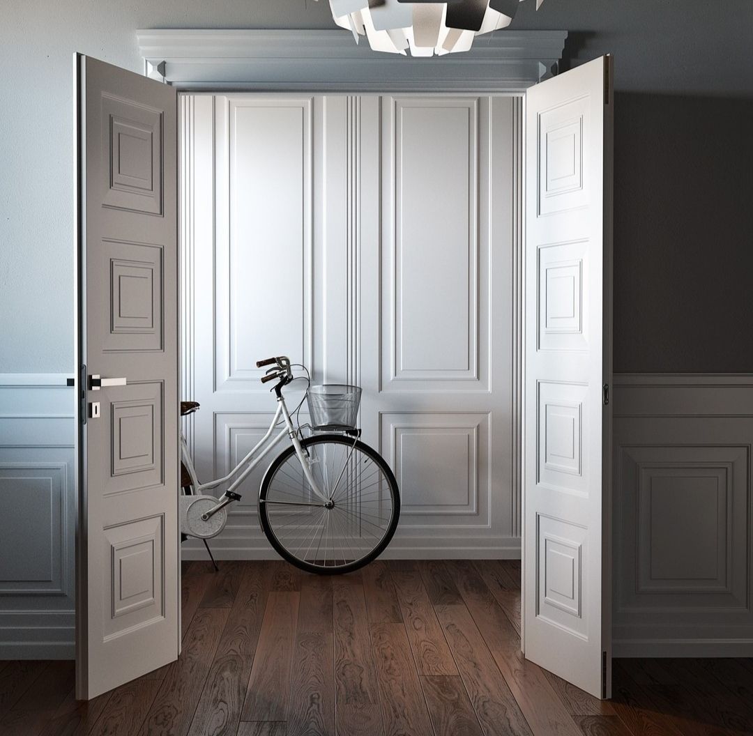 Des portes blanches ouvertes encadrent une pièce aux murs lambrissés blancs, où l'on aperçoit un vélo.