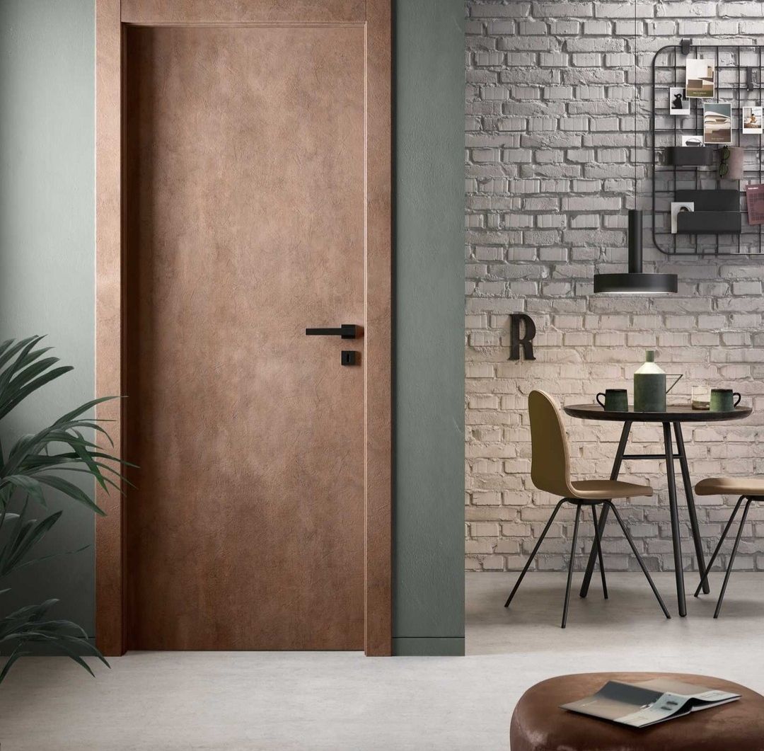 Porte en bois dans une pièce avec un mur en briques, une table et des chaises.