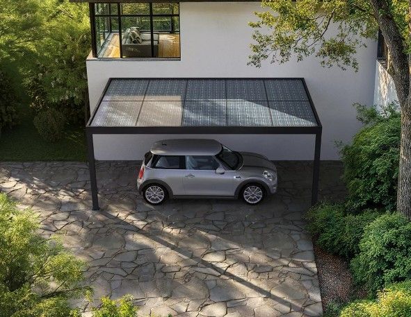Voiture garée sous un abri de voiture à panneaux solaires, allée et maison moderne.