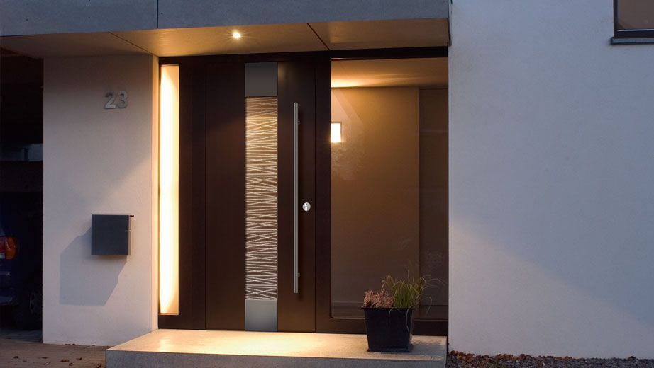 Porte d'entrée d'une maison moderne ; porte marron avec panneau de verre, boîte aux lettres et éclairage chaleureux.
