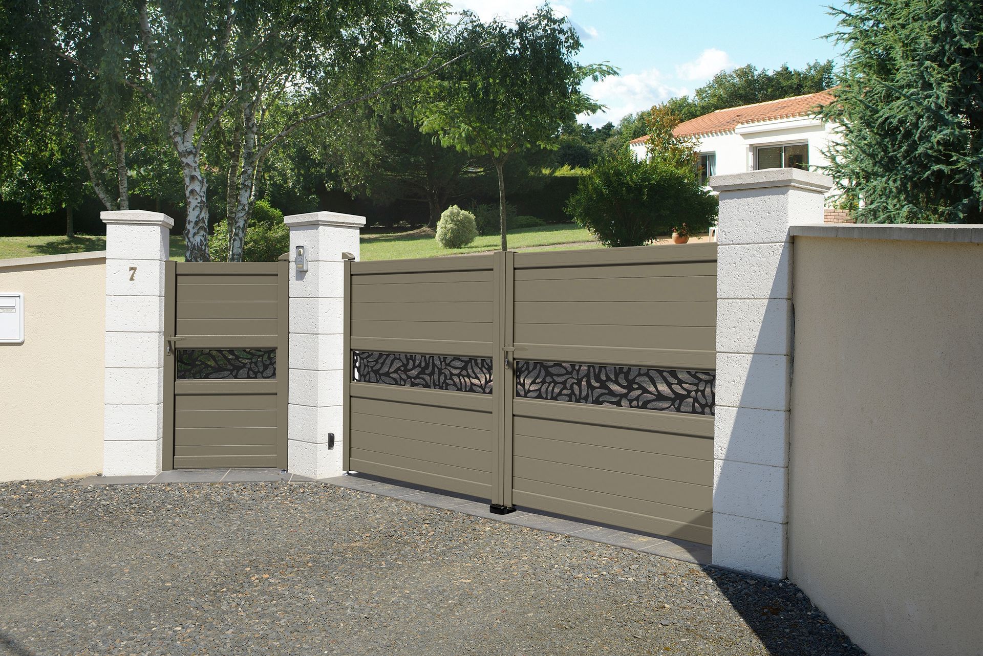 Portail d'allée en métal beige avec panneaux décoratifs et piliers en pierre.